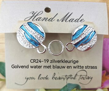 Clips, met golvend water en strass en midden een ring in kleur zilver. 