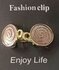 Clips, Spiralsymbol, ein Ring in Goldfarbe._