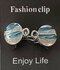 Clips, met golvend water en strass en midden een ring in kleur zilver. _